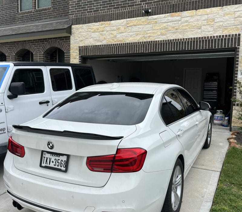 White BMW sedan in a residential garage after interior detailing