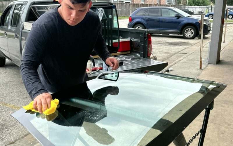 LBG Auto Care technician working on a windshield at a customer driveway in the Houston area