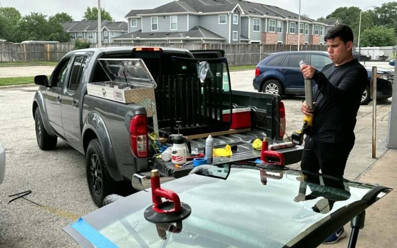 LBG Auto Care technician with his work truck and gear in a Houston residential driveway